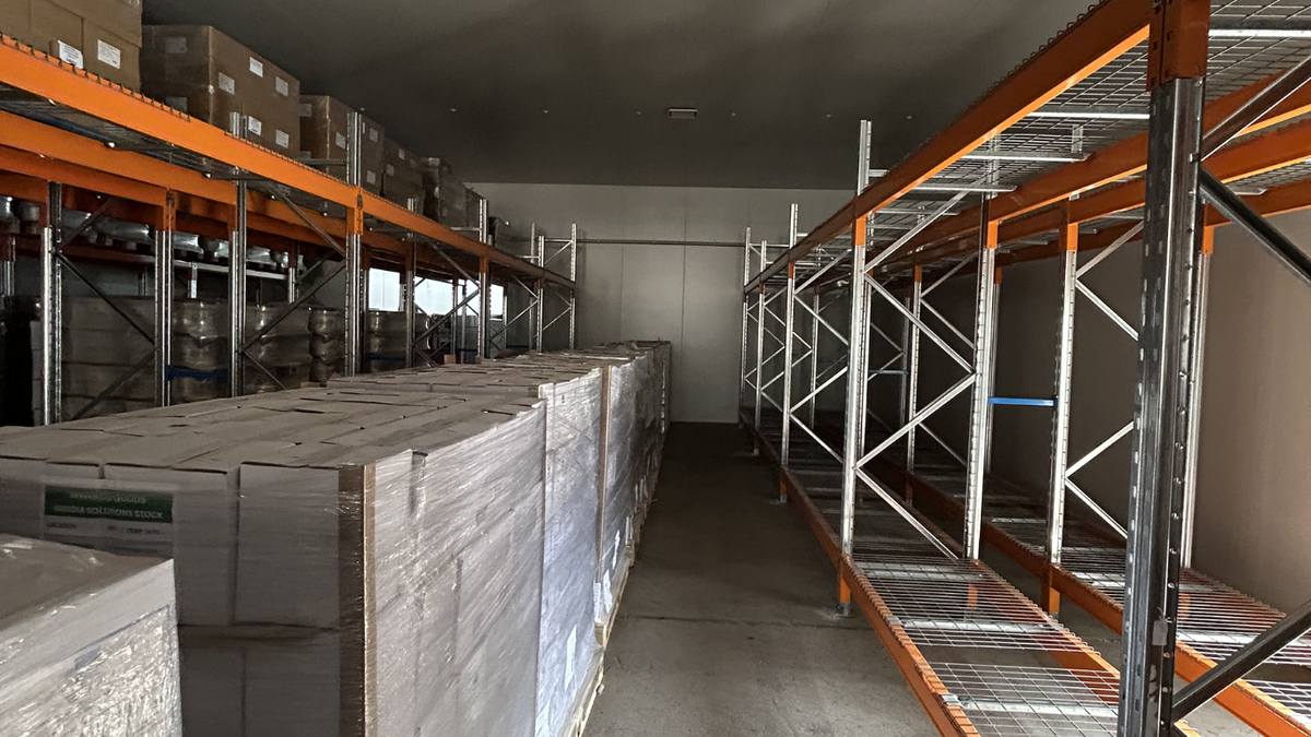 ReadyRack Heavy Duty Shelving with orange beams and galvanised frames and mesh decks in a storeroom